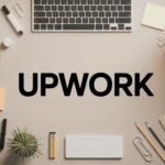 Desk flat lay with laptop, notebook, plant, pencils, coffee cup, and "UPWORK" text in center.